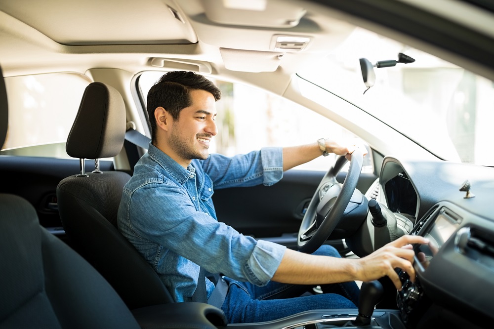 man in car changing radio station